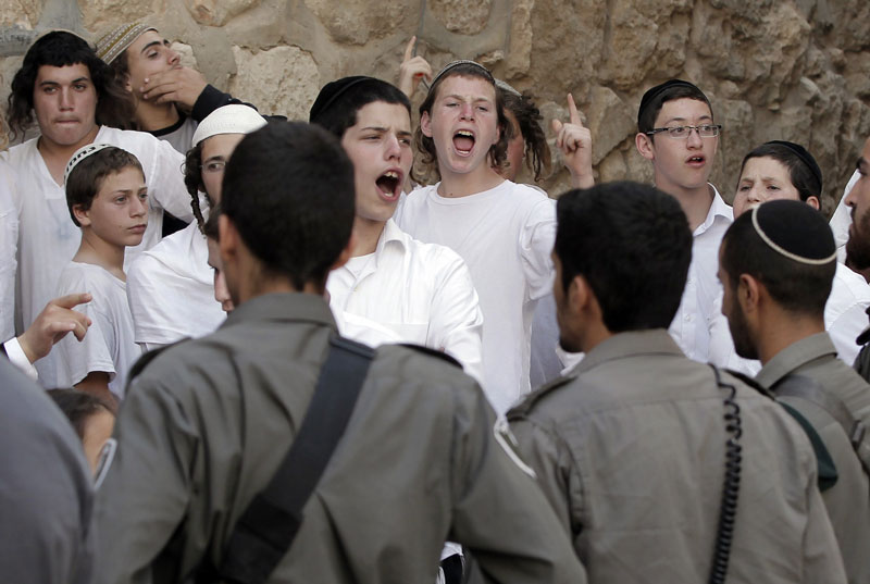 Ultra-Orthodox Jewish youth are surrounded by Israeli police as they heckle Catholics exiting the Cenacle after the Pentecost prayer in 2015. © Getty